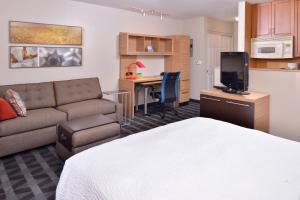 a living room with a bed and a couch and a kitchen at TownePlace Suites by Marriott Ontario Airport in Rancho Cucamonga