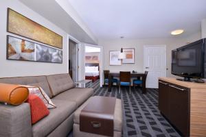 a living room with a couch and a flat screen tv at TownePlace Suites by Marriott Ontario Airport in Rancho Cucamonga