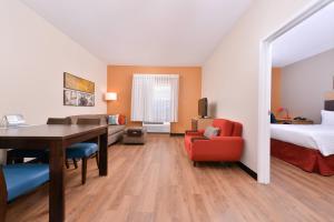 a hotel room with a desk and a bed and a bedroom at TownePlace Suites by Marriott Ontario Airport in Rancho Cucamonga