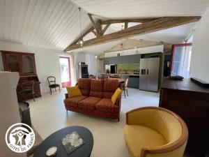 uma sala de estar com um sofá e uma cozinha em Gîte Challans, 4 pièces, 8 personnes - FR-1-426-531 em Challans