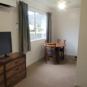 a dining room with a table and chairs and a window at Couples Retreat in Reefton