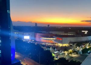 a view of a building with a parking lot at sunset at Platinum II Equipetrol frente Ventura Mall Super Lujo Hermosas Vistas in Santa Cruz de la Sierra