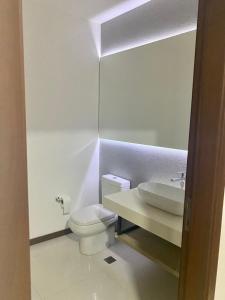 a bathroom with a white toilet and a sink at Platinum II Equipetrol frente Ventura Mall Super Lujo Hermosas Vistas in Santa Cruz de la Sierra