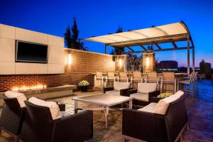 d'une terrasse avec une table, des chaises et une télévision. dans l'établissement Sheraton Overland Park Hotel at the Convention Center, à Overland Park