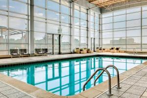 a large swimming pool with glass windows and a large pool at Sheraton Overland Park Hotel at the Convention Center in Overland Park