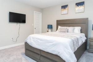 a bedroom with a large bed and a flat screen tv at 3bed 2.5 bath town house in Carmel in Carmel