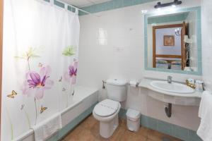 a bathroom with a toilet and a sink and a tub at Hotel Oasis Atalaya in Conil de la Frontera +111 photos