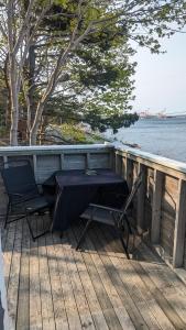 a table and chairs sitting on a deck next to the water at SeaWatch Bed & Breakfast in Halifax