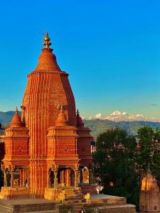 ein großes orangefarbenes Gebäude mit Bergen im Hintergrund in der Unterkunft Shiva Guest House in Bhaktapur