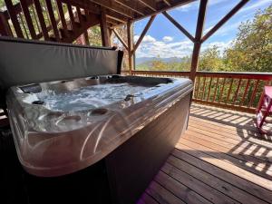 bañera de hidromasaje en una terraza de madera en Red Rooster Family Cabin w/Hot Tub+Fire Pit+View, en Franklin