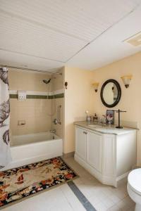 y baño con bañera, lavabo y aseo. en Red Rooster Family Cabin w/Hot Tub+Fire Pit+View, en Franklin