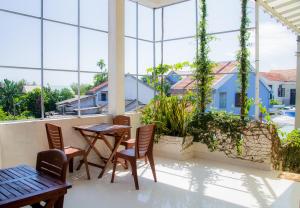 a balcony with a table and chairs and windows at Skybird Homestay in Hoi An