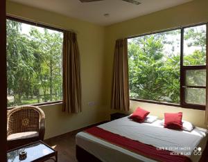 1 dormitorio con 1 cama y 2 ventanas grandes en Nalgarh Retreat - JUNGLE RESORT by StayApart en Uttar Simlabari