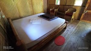 Una cama en una habitación con un ordenador portátil. en Nature Hunt Eco Camp, en Kāziranga