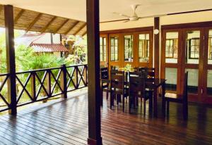 a dining room and a balcony with a table and chairs at Private Tropical 3 Bedroom Villa - Nongsa Village Batam in Telukmataikan