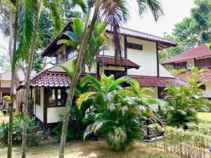 a house with palm trees in front of it at Private Tropical 3 Bedroom Villa - Nongsa Village Batam in Telukmataikan