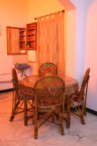 a dining room table with chairs and a table at Nanda Gokula Homestay in Auroville