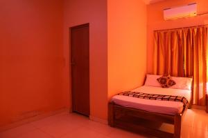 a small room with a bed and a window at Nanda Gokula Homestay in Auroville