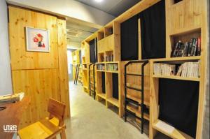 una fila de estanterías de madera en una biblioteca en Route Five Hostel Dorm Kuala Selangor, en Kuala Selangor