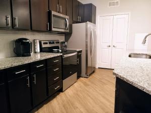 a kitchen with black cabinets and a white refrigerator at "Two Bella" Luxury Apt - POOL - 4 Mi to Beach in Daytona Beach