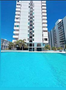 a large swimming pool in front of a tall building at Feeling Tip’Sea in San Juan