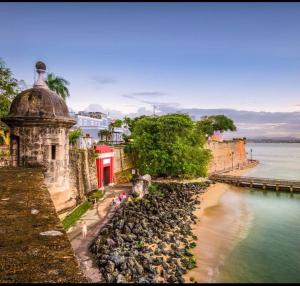 eine Gruppe von Menschen, die am Strand in der Nähe des Wassers stehen in der Unterkunft Feeling Tip’Sea in San Juan