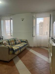 un soggiorno con divano e 2 finestre di Brezza Marina 3021 a Genova