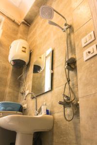 uma casa de banho com um chuveiro e um lavatório. em Ithaka Hostel em Alexandria