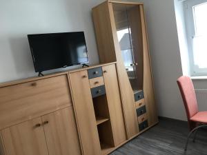 un televisor en la parte superior de un armario de madera con un televisor en él en Apartment im Stadthaus, en Finsterwalde