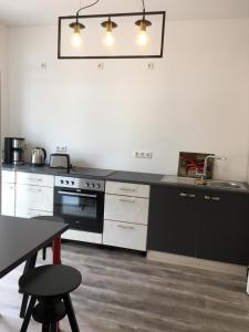 a kitchen with a black counter top and a table at Apartment im Stadthaus in Finsterwalde