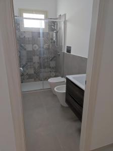 een badkamer met een douche, een toilet en een wastafel bij Villa Rita in Fontane Bianche