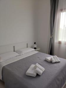 een slaapkamer met 2 handdoeken op een bed bij Villa Rita in Fontane Bianche
