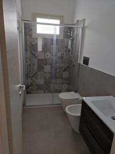 een badkamer met een douche, een toilet en een wastafel bij Villa Rita in Fontane Bianche