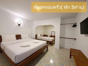 um quarto de hotel com duas camas e uma televisão em Nan Lanna Hotel em Nan