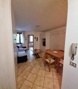 a living room with a table and a couch at Appartamento Val di Luce Relax Cristallo in Abetone