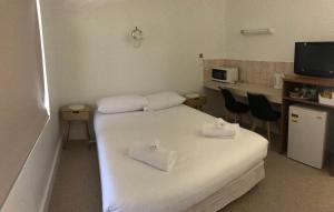 a small room with two beds and a kitchen at Billabong Wangaratta in Wangaratta