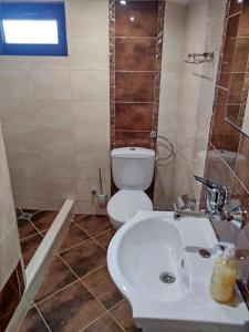 Łazienka z białą toaletą i umywalką w obiekcie Guest house-restaurant St. George / Къща за гости-ресторант Свети Георги w mieście Gabrowo