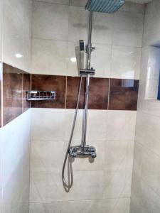 y baño con ducha con cabezal de ducha. en Guest house-restaurant St. George / Къща за гости-ресторант Свети Георги, en Gabrovo