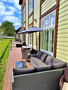 un patio al aire libre con sofá y sombrilla en Aleksi Apartments, en Tartu
