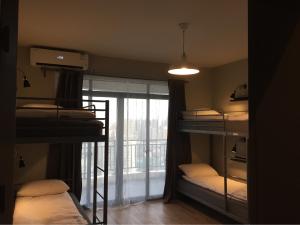 a room with three bunk beds and a window at Ma Cherie Homestay in Shanghai