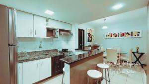 a kitchen with white cabinets and a counter top at Beira-mar em Pajuçara com excelente localização in Maceió