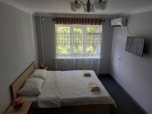 um pequeno quarto com uma cama e uma janela em Aisha Registan em Samarkand