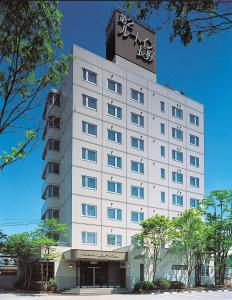 un gran edificio blanco con un cartel encima en Hotel Route-Inn Daini Nagano, en Nagano