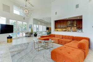 a living room with orange couches and a flat screen tv at Beverly Hills City View Mansion in Los Angeles