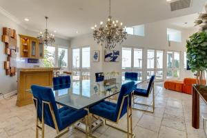 a dining room with a glass table and blue chairs at Beverly Hills City View Mansion in Los Angeles