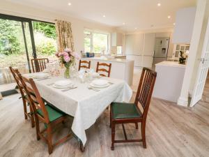 a dining room table with chairs and a kitchen at 7 Old Rectory Gardens in Kingsbridge