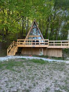 ein Fachwerkhaus mit einer Treppe und einer Terrasse in der Unterkunft CabanaAframe intreaga proprietate in Curtea de Argeş