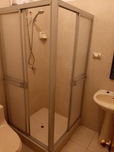 La salle de bains est pourvue d'une douche avec une porte en verre. dans l'établissement 203 RV Apartments Iquitos-Apartamento con dos habitaciones, à Iquitos