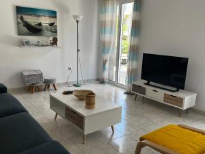een woonkamer met een bank en een tv bij Popi's Place in Rhodos-stad