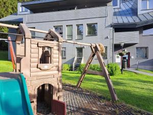 a wooden playset in the yard of a house at Wellness Apartment Josefina - Free Grotta Spa wellness in Harrachov
